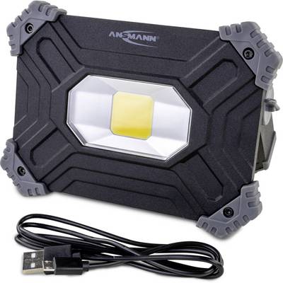 Projecteur LED noir avec coins gris, de marque Ansmann, à côté d'un câble USB.