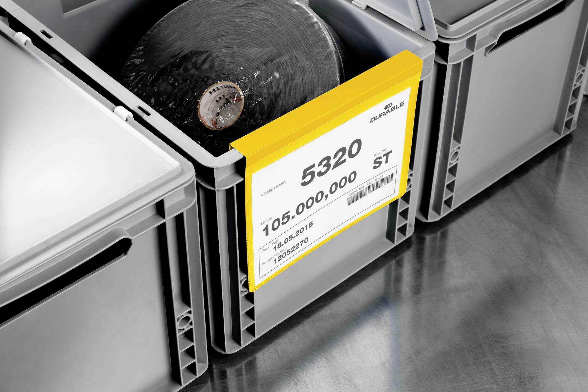 Caisse en plastique grise avec étiquette '5320', '105.000.000 PCS'. Une autre caisse similaire est visible à côté.