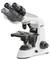 Un microscope blanc avec des oculaires orientables, trois objectifs et une platine réglable. Marquage 'KERN' visible.