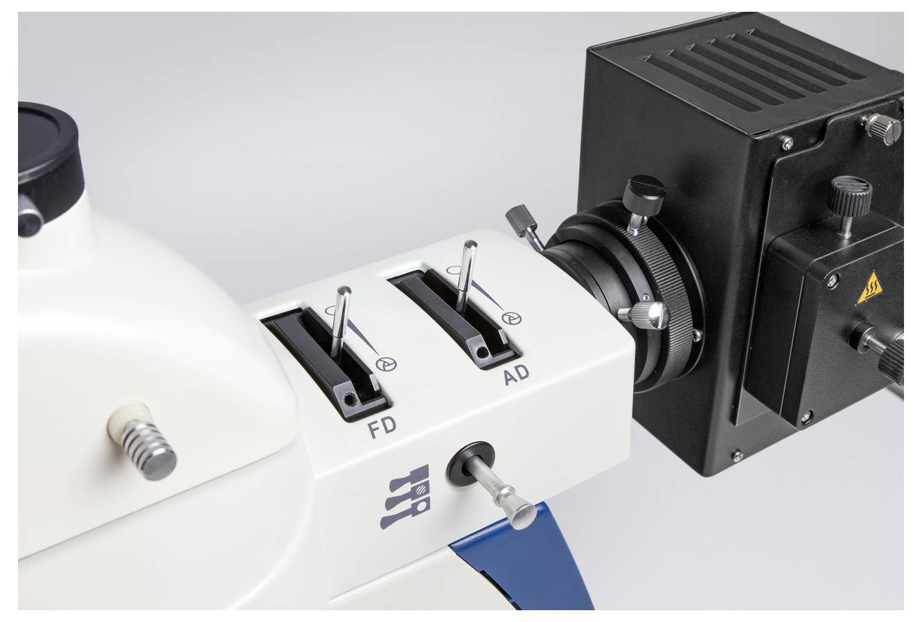 Un microscope doté de deux leviers de réglage et d'un dispositif de connexion pour caméra, adapté aux investigations scientifiques précises.