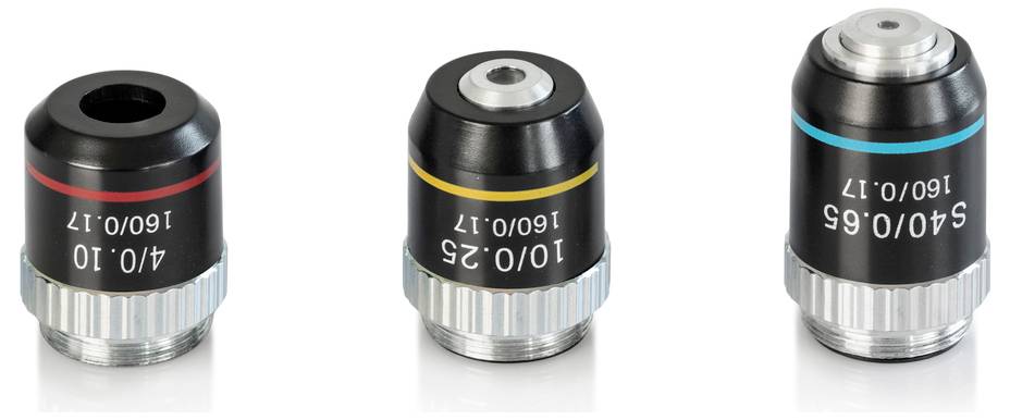 Trois objectifs de microscope avec des spécifications différentes sont visibles côte à côte. Ils ont des bagues colorées pour les différencier.