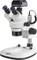 Un microscope stéréoscopique blanc avec deux oculaires, rotation horizontale, bouton de mise au point et éclairage LED lumineux, installé sur un support stable.
