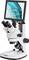 'Un microscope avec moniteur affiche un tissu cellulaire agrandi aux teintes bleu-vert.'
