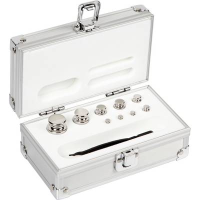 Une mallette ouverte en aluminium garnie de mousse présente divers poids de calibrage chromés et une pince brucelles.