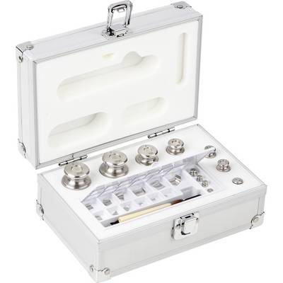 Une valise métallique ouverte montre un ensemble de poids de différentes tailles et formes, soigneusement rangés dans des compartiments adaptés.