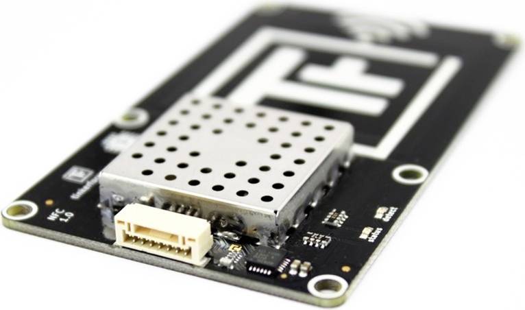Circuit électronique avec un module métallique perforé au centre, connecteur sur le côté ; probablement un capteur radio.