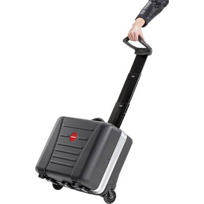 Une personne tire une valise à roulettes noire avec une poignée télescopique, adaptée aux voyages.