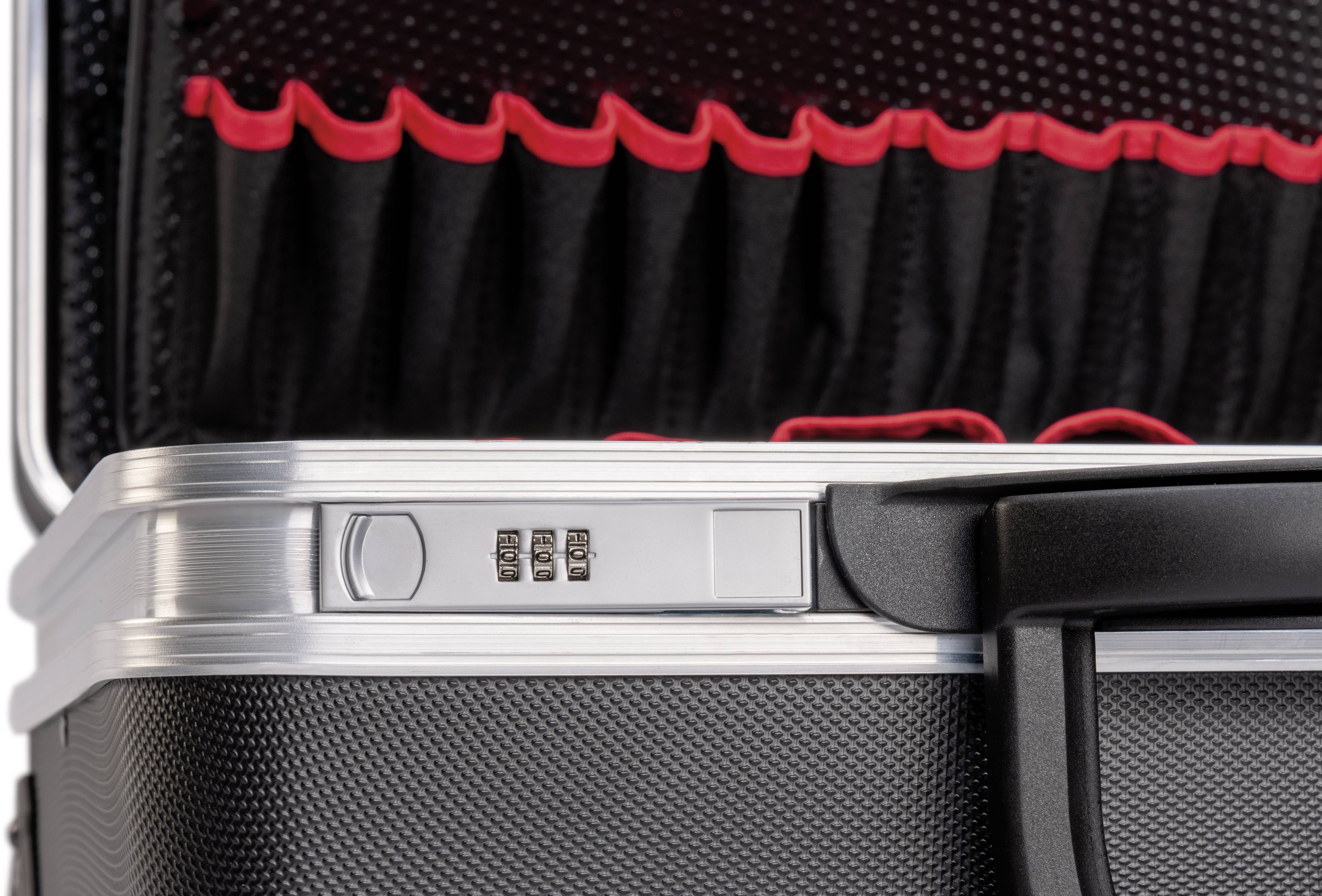 Valise rigide noire avec serrure à combinaison et pochette intérieure à bord rouge, positionnée pour être verrouillée.
