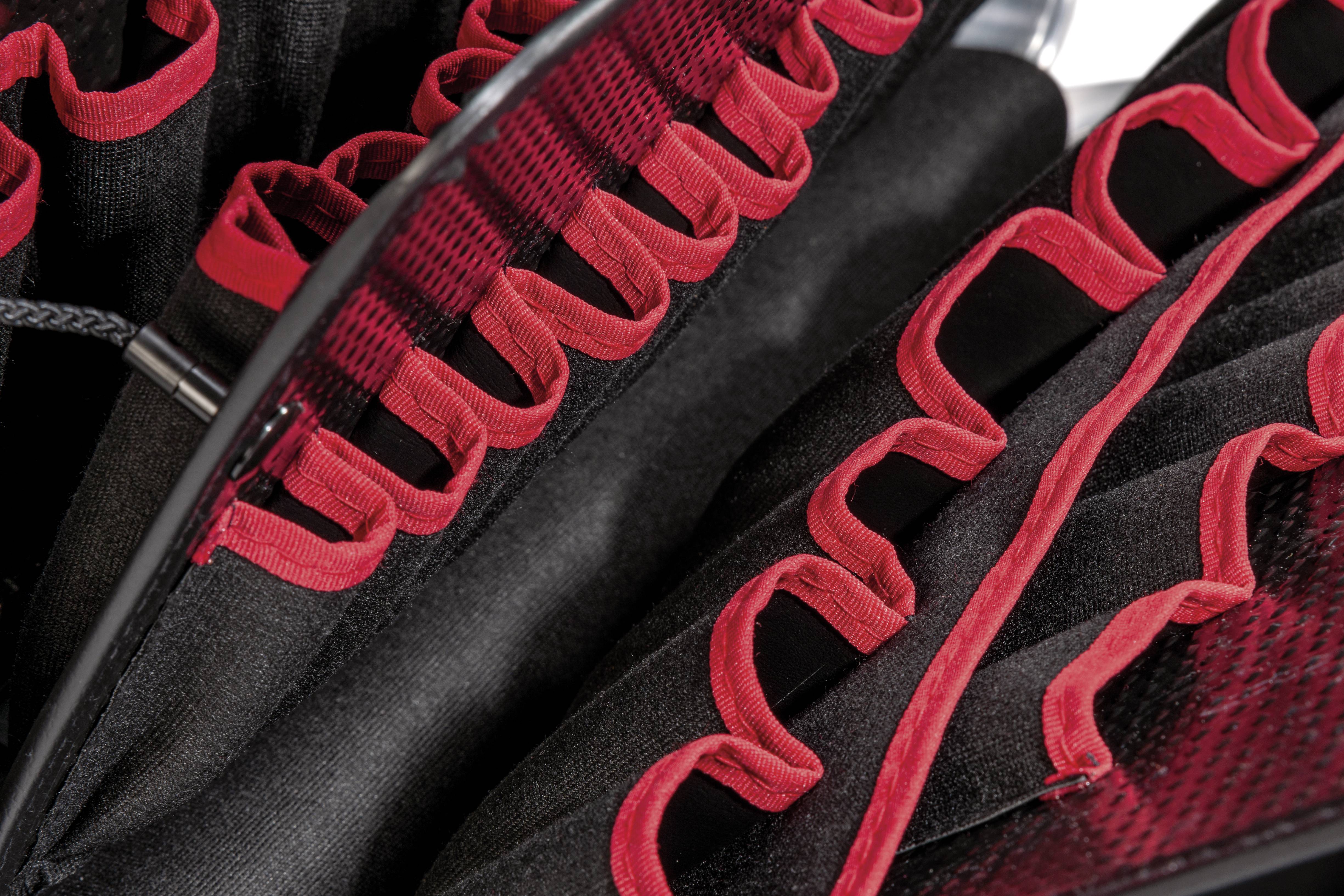 Gros plan sur une structure de tissu avec des motifs rouges et noirs. La caractéristique principale est constituée de boucles rouges sur des surfaces noires.