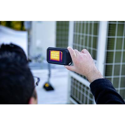 Une personne tient un appareil qui affiche le rayonnement thermique d'un objet. L'écran montre une image thermique dans différentes nuances de couleur.