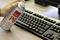 Une main tient une bombe d'air comprimé au-dessus d'un clavier d'ordinateur pour enlever la poussière.