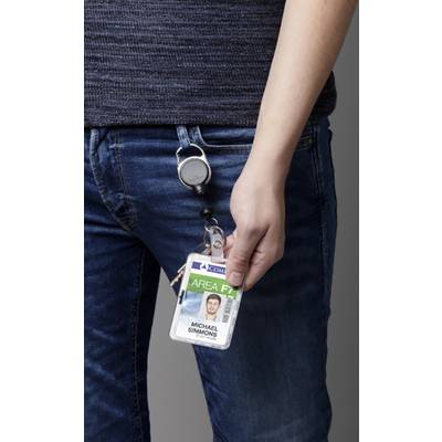 Une personne tient une carte d'identité attachée à son jean avec un clip. La carte montre une photo et le nom "Michael Simmons".