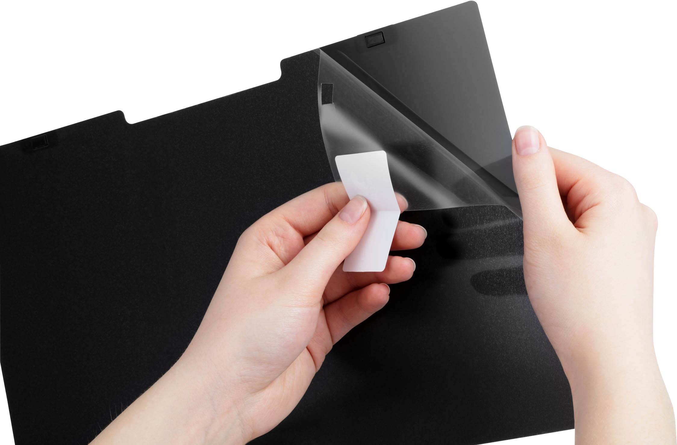 Deux mains retirent un film protecteur transparent d'un filtre d'écran noir.