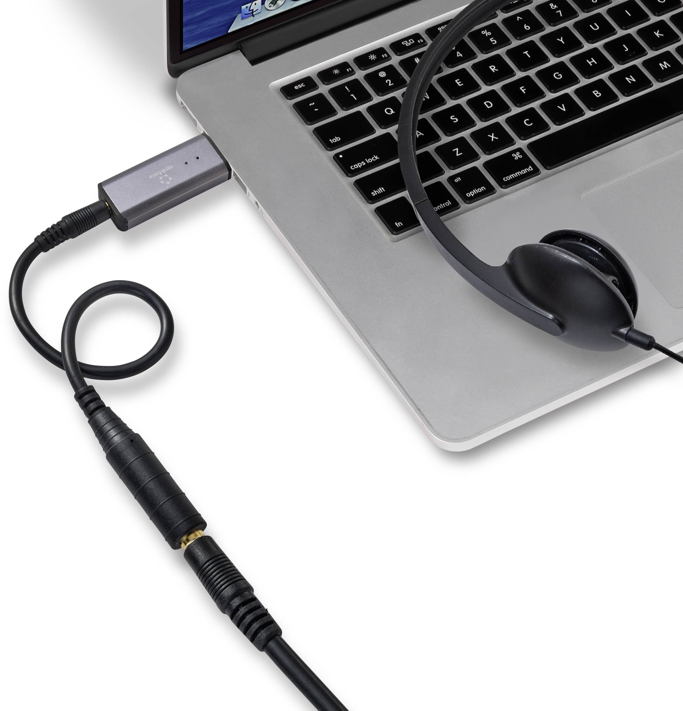 Un ordinateur portable avec un casque connecté et un câble audio relié par un adaptateur.