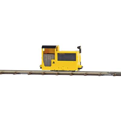 Une petite locomotive miniature jaune sur rails. Elle possède un poste de conduite ouvert et des détails en noir.