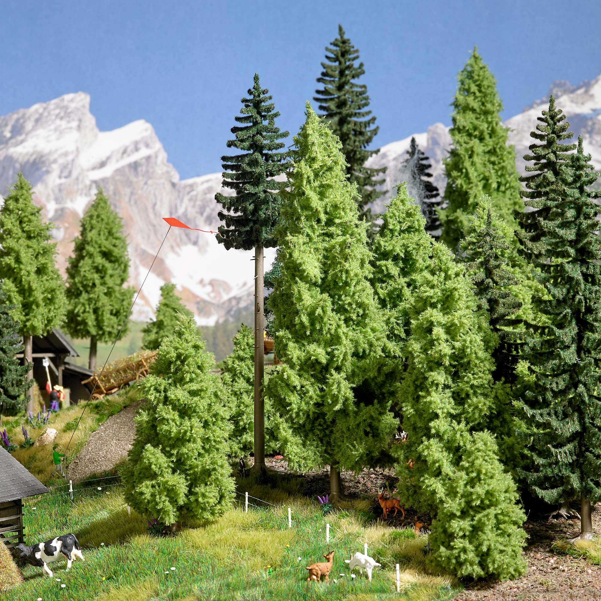 Paysage miniature avec des montagnes en arrière-plan, des arbres élevés, des animaux et une maison. Un dragon rouge vole entre les arbres.