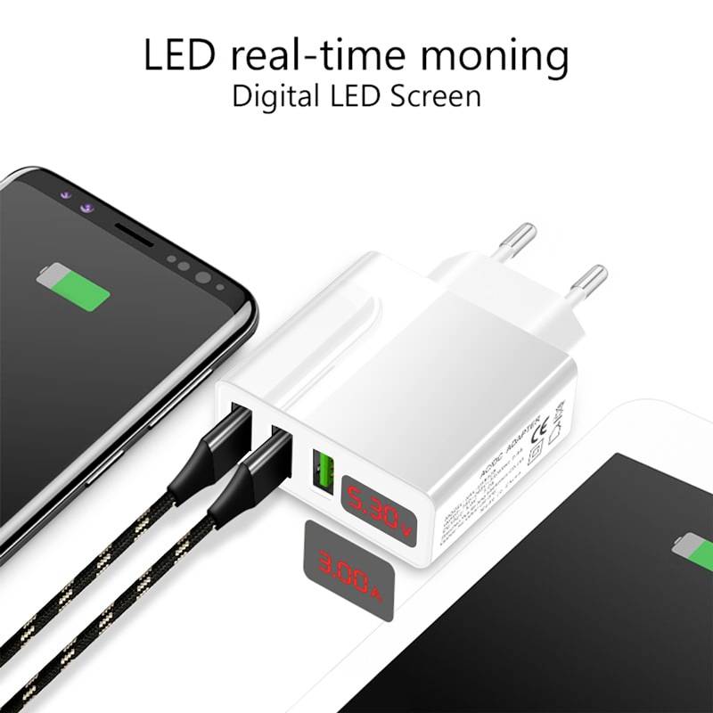 Un smartphone est en cours de chargement, connecté à un adaptateur blanc. L'adaptateur affiche un écran LED indiquant '5.0V 3.0A'.
