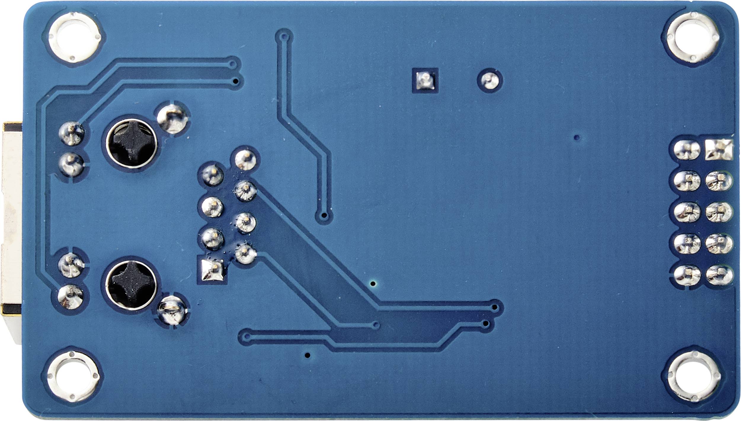 Une carte électronique bleue avec plusieurs points de soudure, deux vis noires et des circuits visibles.