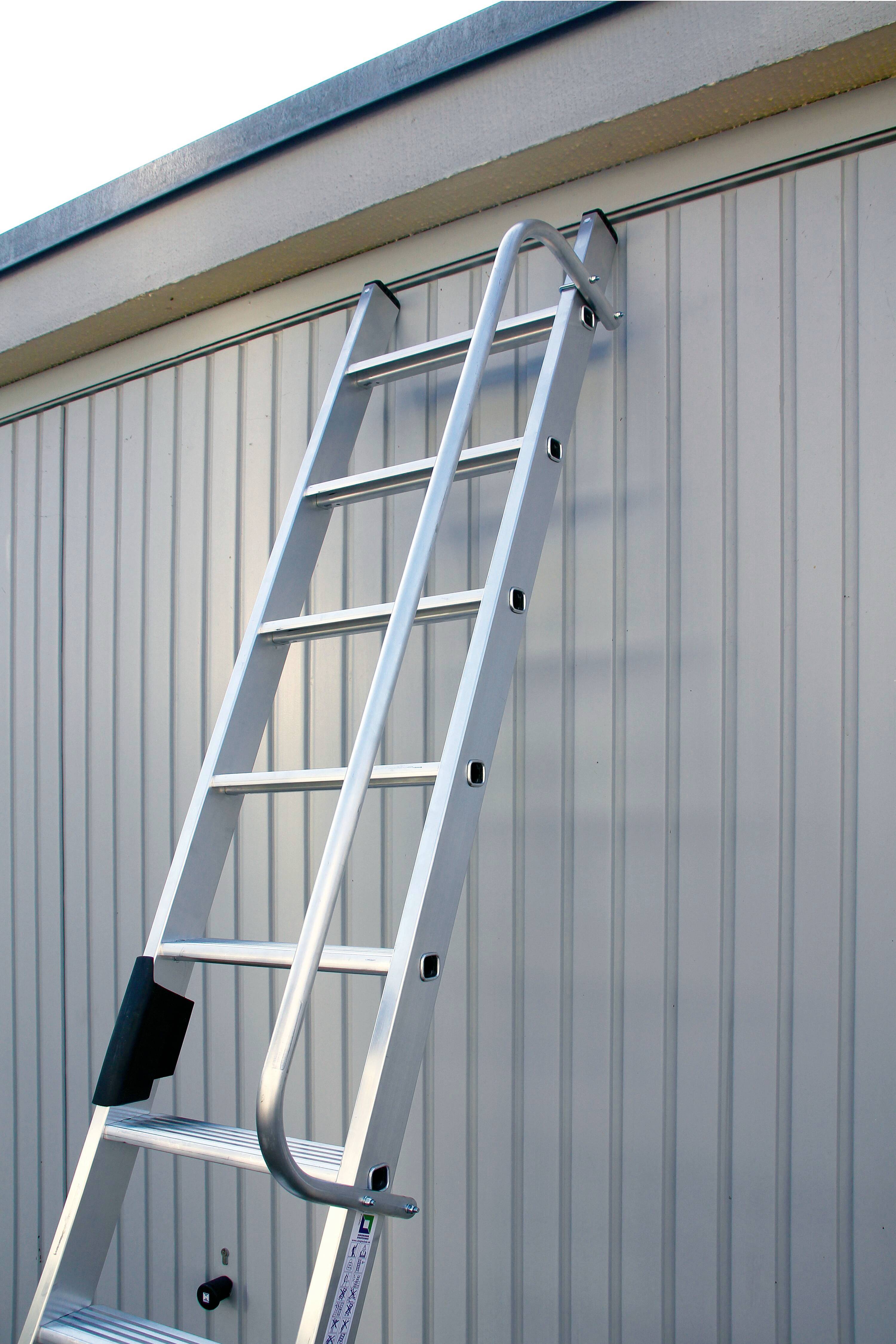 Une échelle en aluminium est appuyée contre un mur.
