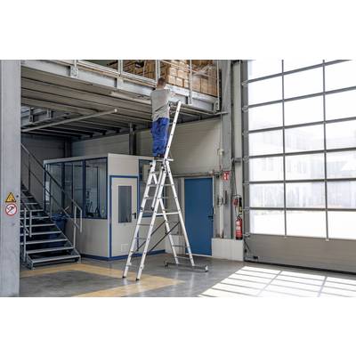 Une personne est debout sur une échelle dans un atelier, travaillant sur une étagère. Une porte bleue et une cabine vitrée sont visibles en arrière-plan. La sécurité est primordiale.