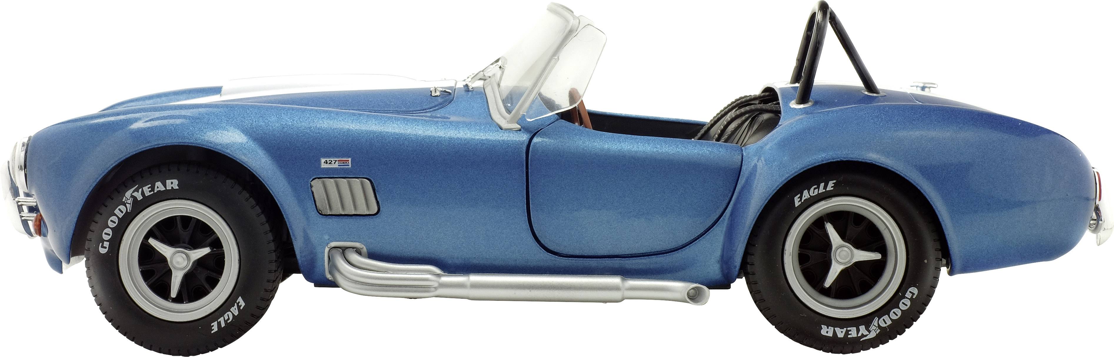 Une voiture décapotable classique bleue de profil avec des bandes de course et des pneus Goodyear.