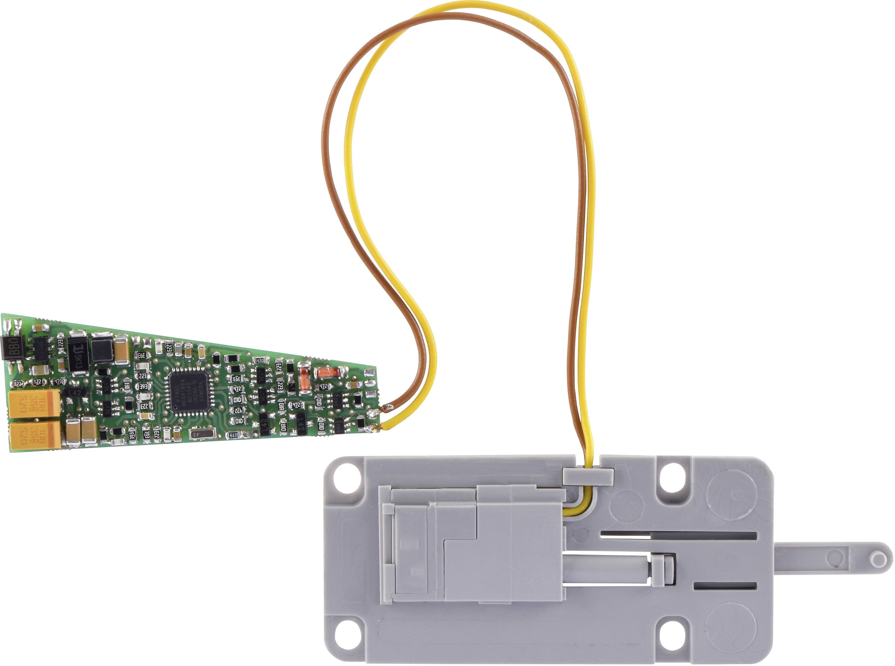 Circuit électronique avec carte de circuit imprimé et boîtier gris, relié par deux câbles de couleur ; semble être destiné au contrôle.