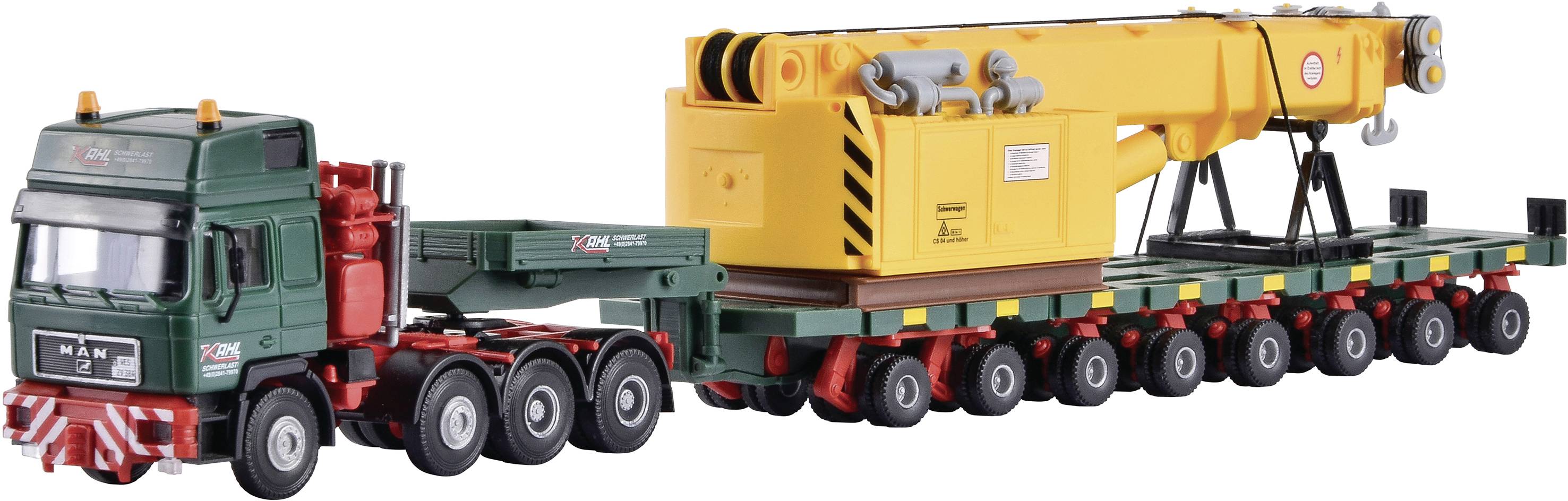 Un camion-modèle vert avec une grande grue jaune montée sur une remorque à essieux multiples.