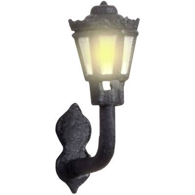 Applique murale noire au design décoratif, diffusant une lumière jaune chaleureuse. Idéale pour un éclairage extérieur ambiant.