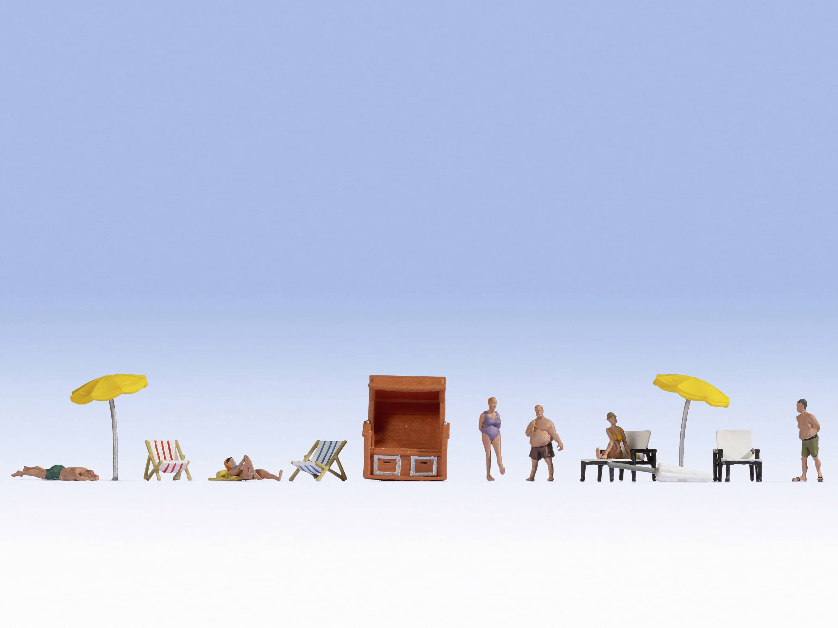 Figurines miniatures sur une plage avec des chaises longues colorées, des parasols jaunes et un panier de plage. Un ciel bleu clair en arrière-plan.