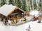 Une scène miniature enneigée représente le Pub de Joseph avec des skieurs et des bonshommes de neige. Des personnes, vêtues de tenues d'hiver, sont occupées.