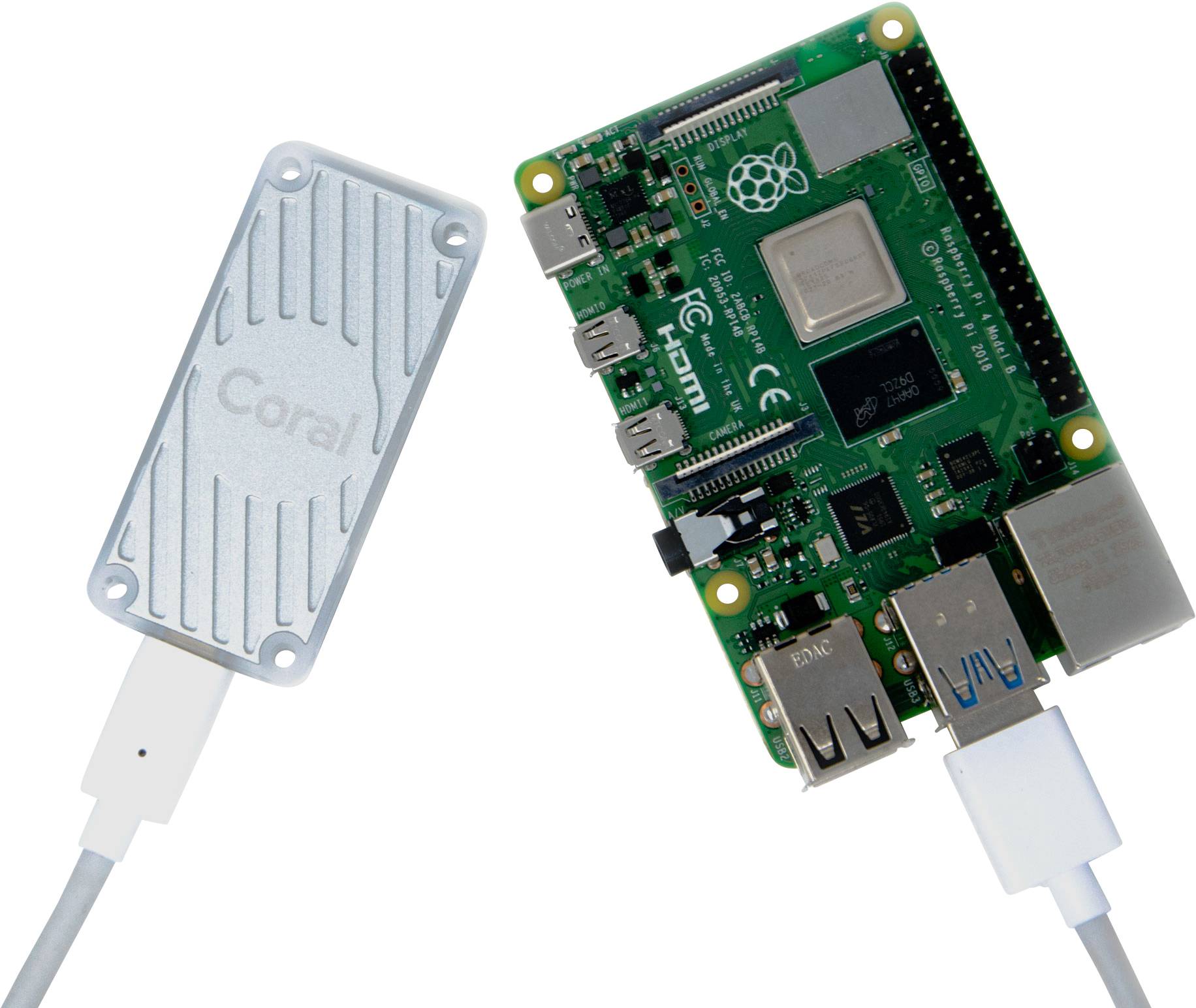 Un module informatique vert à circuit imprimé et un périphérique blanc portant l'inscription 'Coral' sont connectés par un câble.