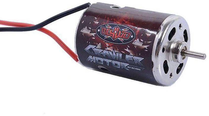 Un petit moteur électrique avec un boîtier rouge et deux câbles. Inscription : « Moteur de chenille ». Utilisé dans les véhicules télécommandés.