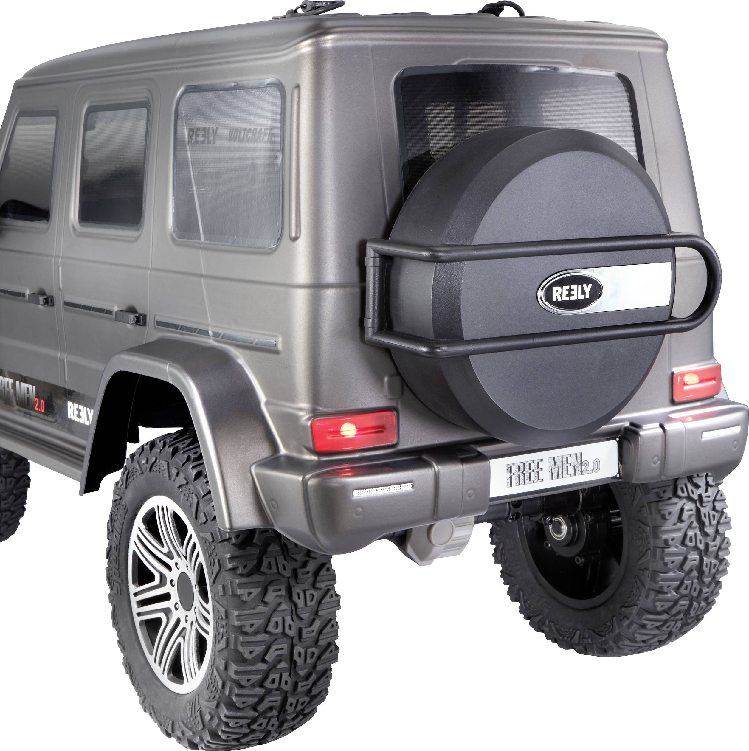 SUV télécommandé miniature en tons de gris. Pneus robustes, roue de secours à l'arrière. Logo de marque automobile visible. Adapté pour le tout-terrain.