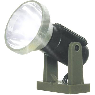 Lampe de poche allumée, montrant un réflecteur argenté brillant et un boîtier noir sur un support vert.