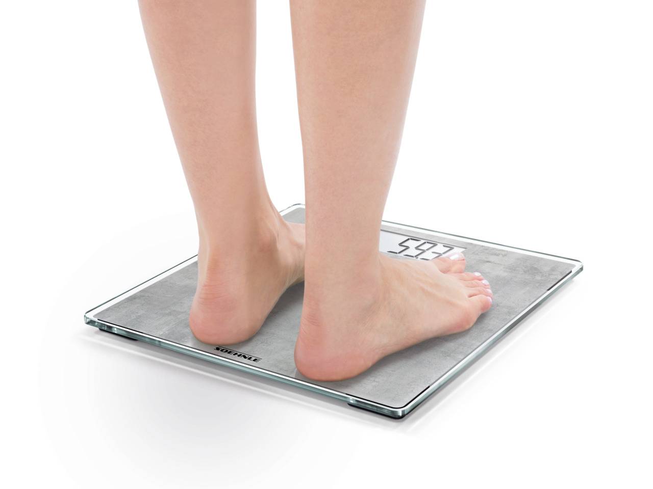 'Une personne se tient pieds nus sur une balance numérique.'