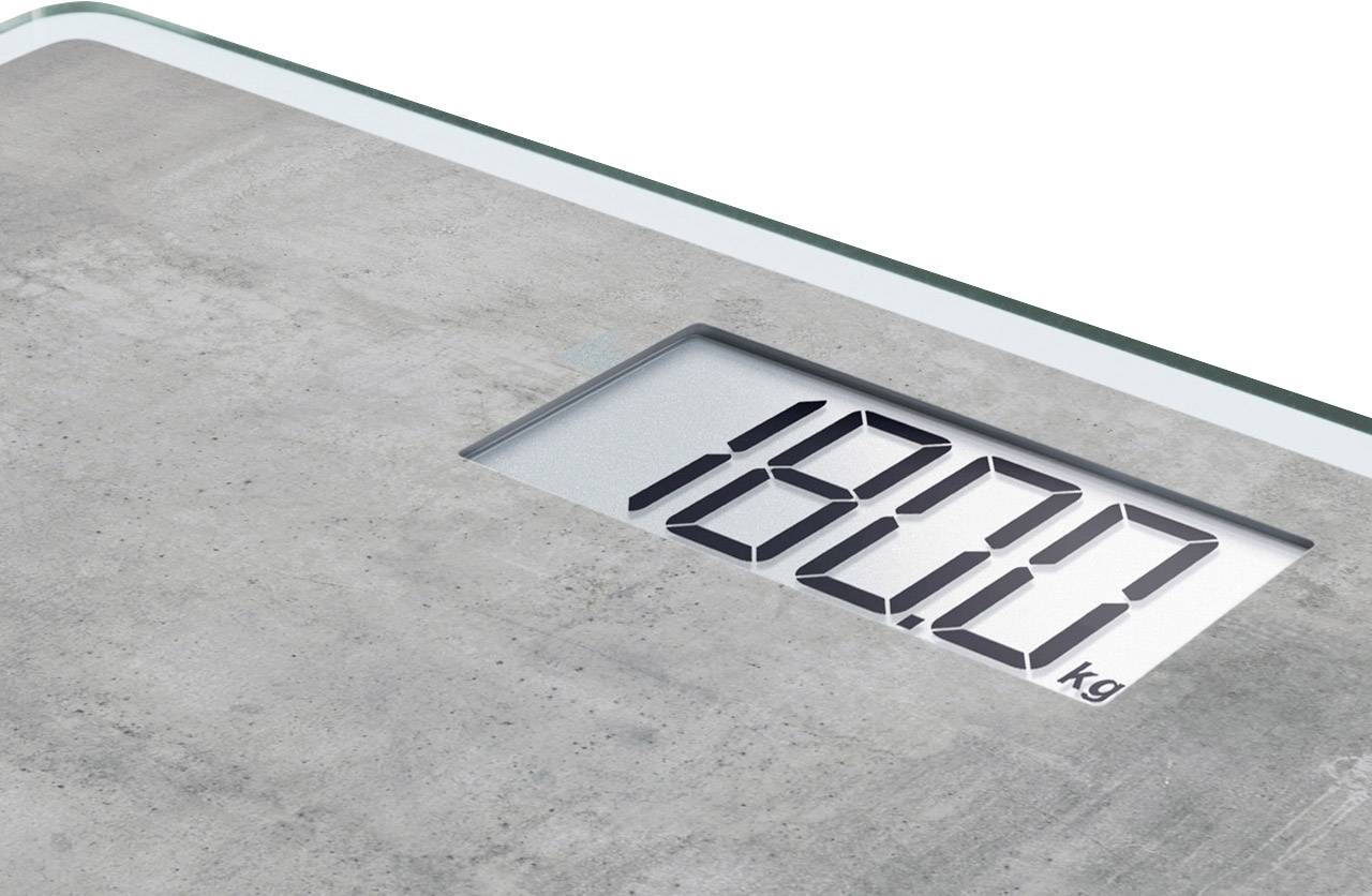 Balance numérique affichant '18,00 kg'. Design moderne et épuré avec surface en verre.