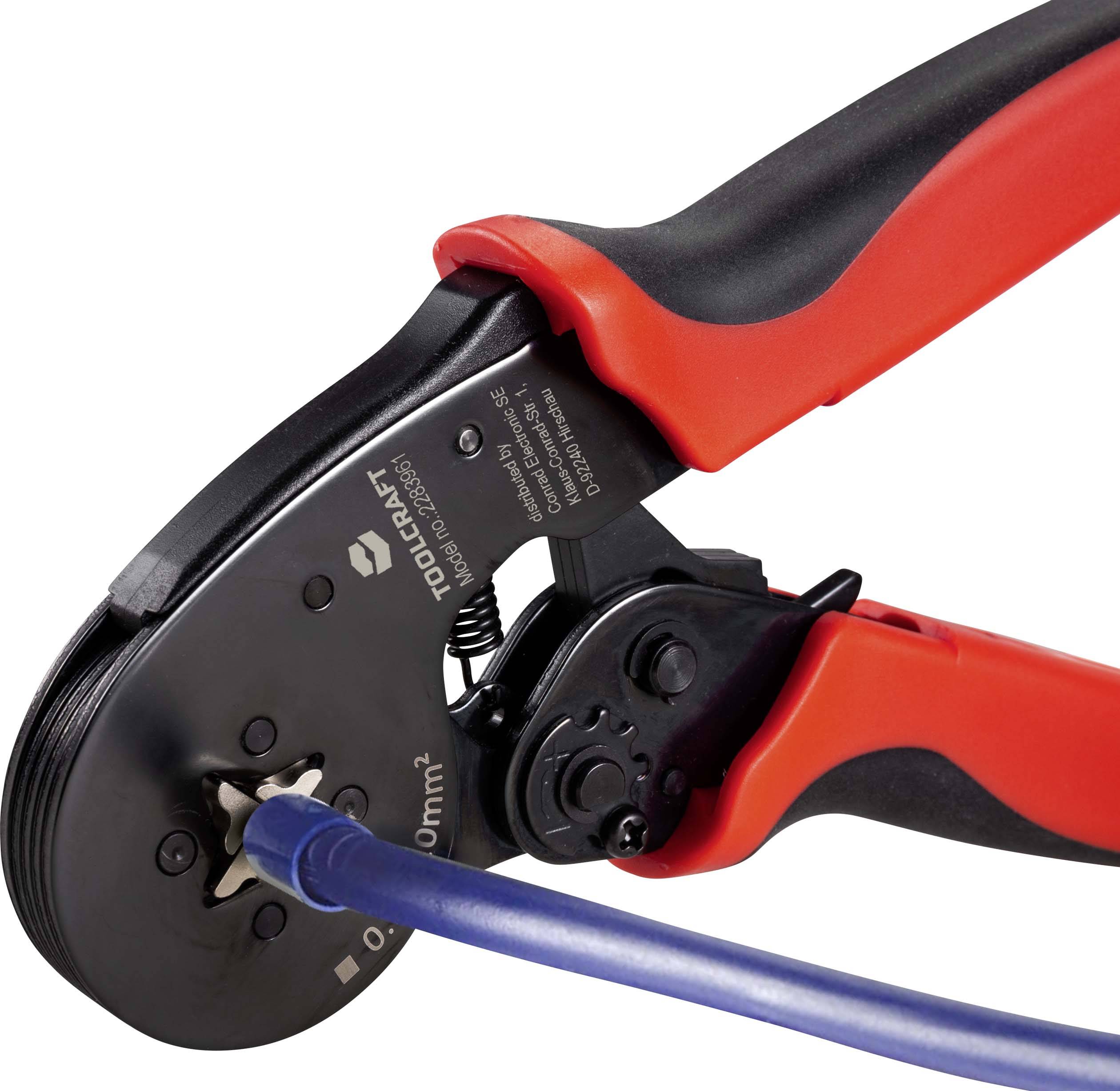 Une pince rouge et noire est utilisée pour sertir un câble bleu.