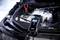 Un chargeur de batterie AEG est connecté à la batterie de voiture, affiche une tension de 14,2 V et est en cours de test.