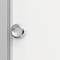 Un gros plan d'un bouton de porte métallique sur une porte blanche. Un bord vertical gris est visible à gauche.