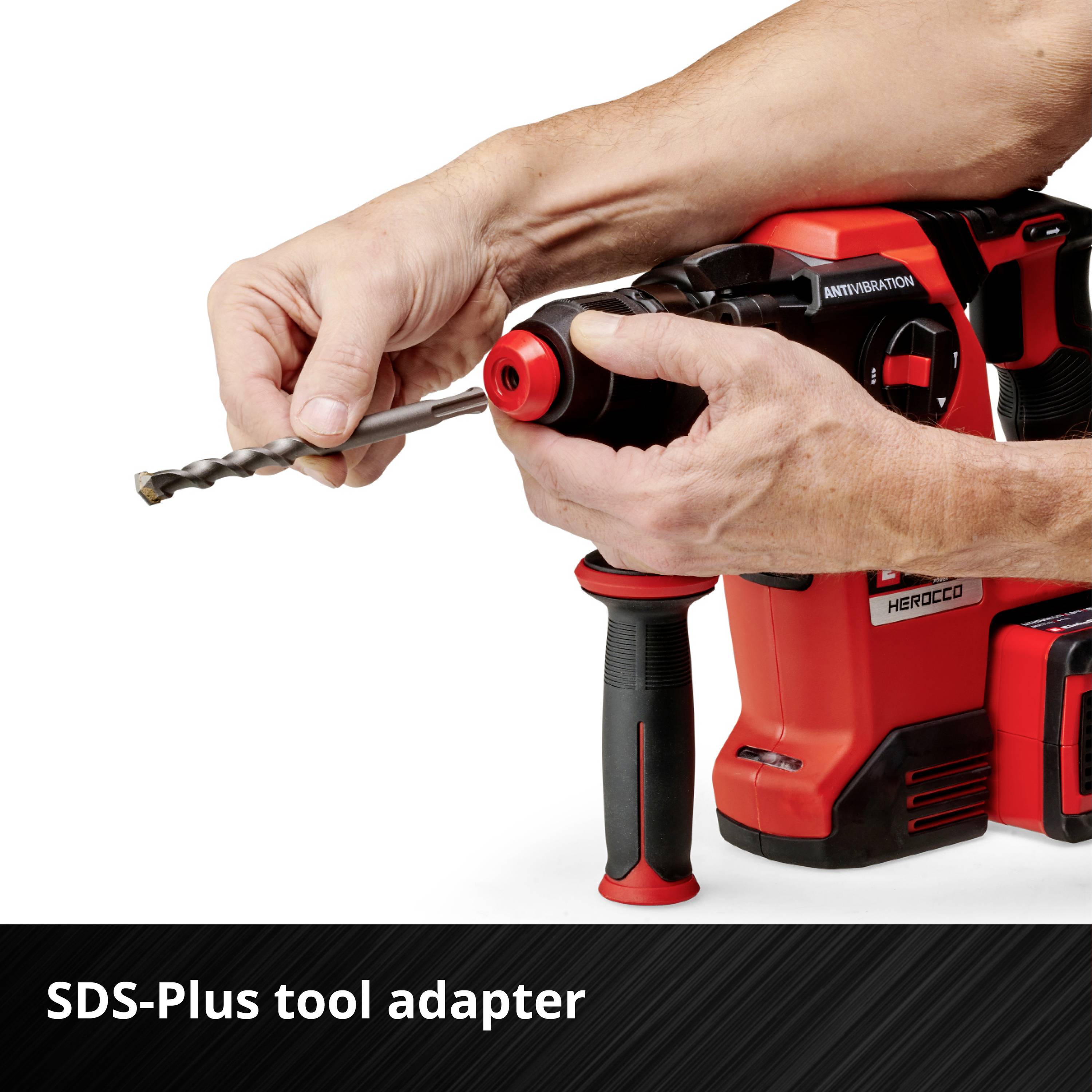 Un homme tient une perceuse SDS-Plus rouge avec fonction anti-vibration.