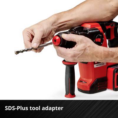 Un homme tient une perceuse SDS-Plus rouge avec fonction anti-vibration.