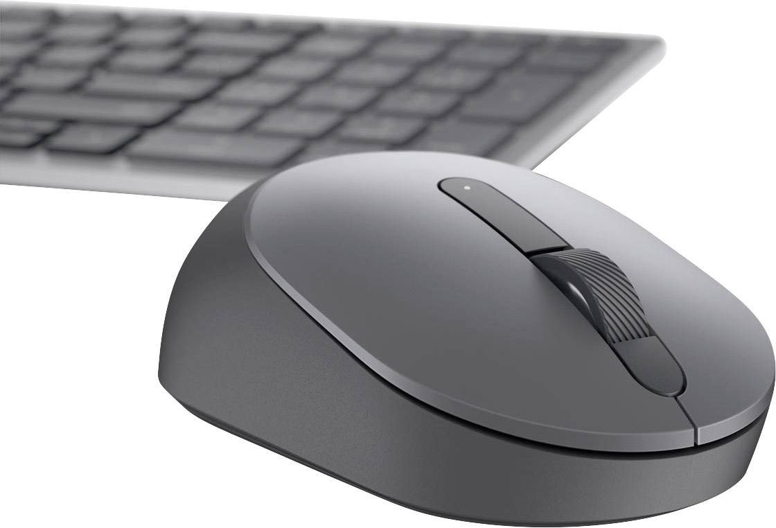 Souris d'ordinateur sans fil grise avec molette de défilement au premier plan, clavier noir en arrière-plan. Adaptée aux environnements de travail modernes.