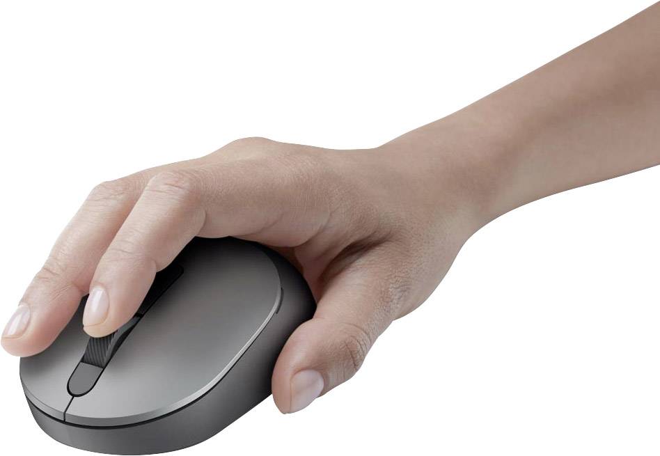 Une main tient une souris d'ordinateur grise posée sur une surface blanche.