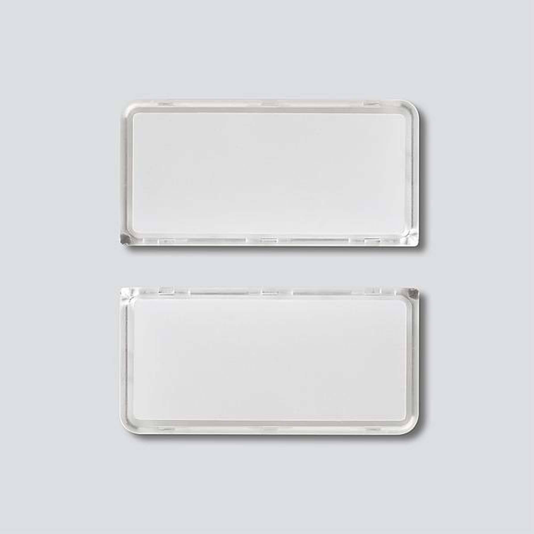 Deux badges nominatifs vierges, rectangulaires et blancs sur un fond gris.