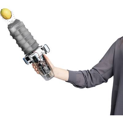 Une personne tient un bras robotique équipé d'une pince flexible soulevant un citron. Le bras démontre la technologie moderne.