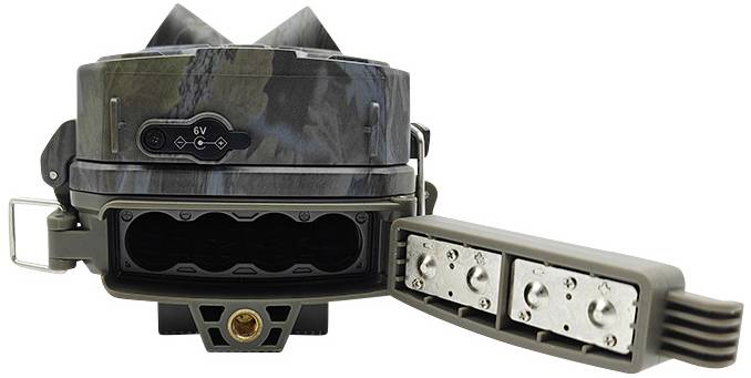 Un appareil avec un motif de camouflage et quatre prises de courant sur le côté. Il dispose d'une connexion de 6V et est probablement conçu pour des utilisations en extérieur.