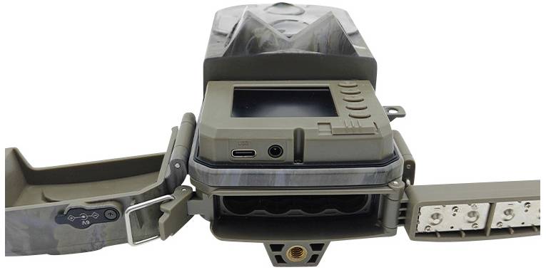 Une caméra de surveillance ouverte avec un écran visible et des commandes. À gauche se trouve le compartiment de la batterie, à droite les LED infrarouges.