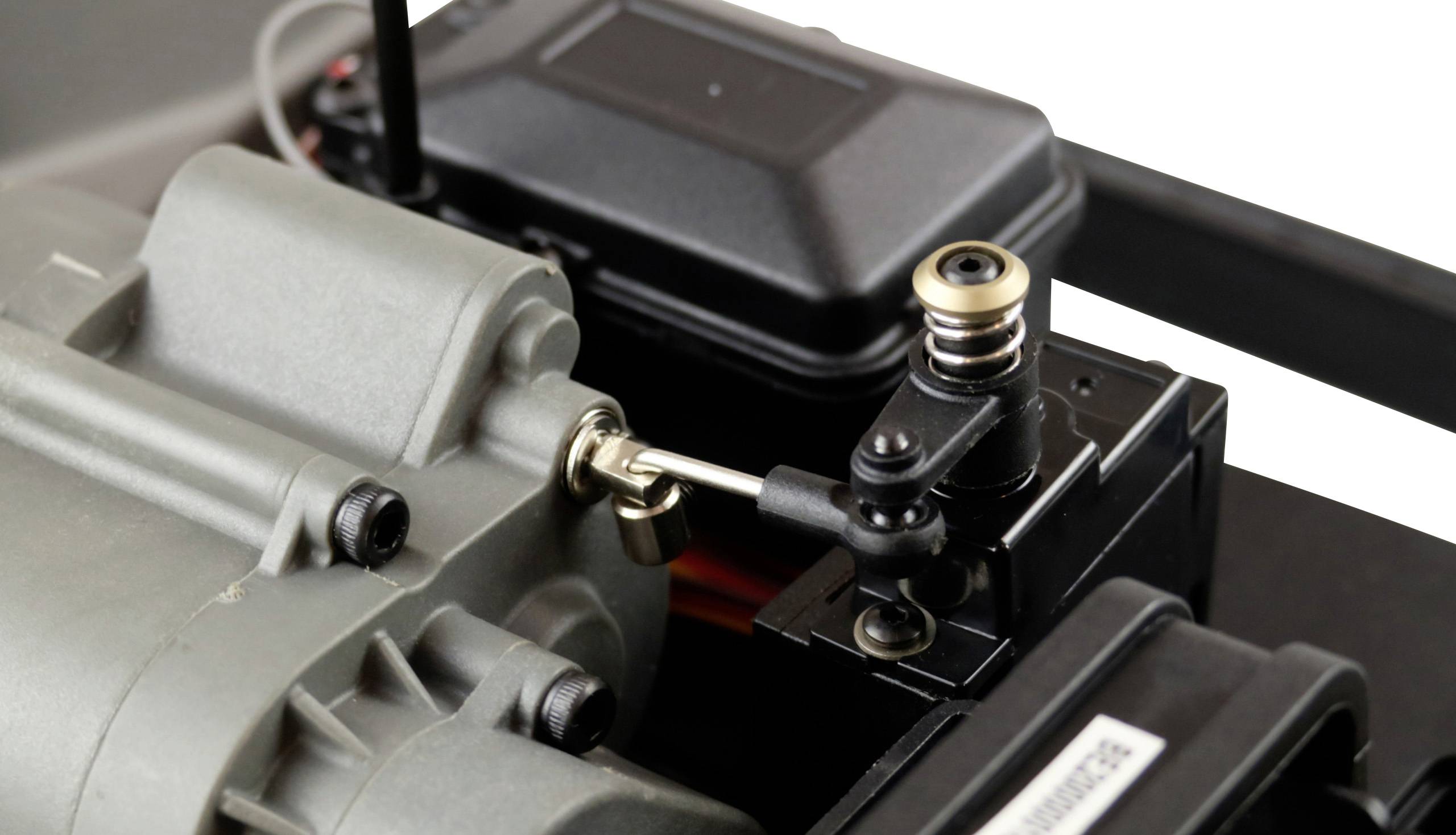 Gros plan d'un servo-réducteur de modélisme avec un bras de levier, monté sur un moteur gris. Il montre les détails mécaniques de la connexion.