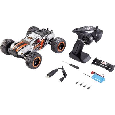 Voiture télécommandée de style monster truck avec télécommande et accessoires, comprenant batterie, câble de chargement USB, tournevis et pièces de rechange.