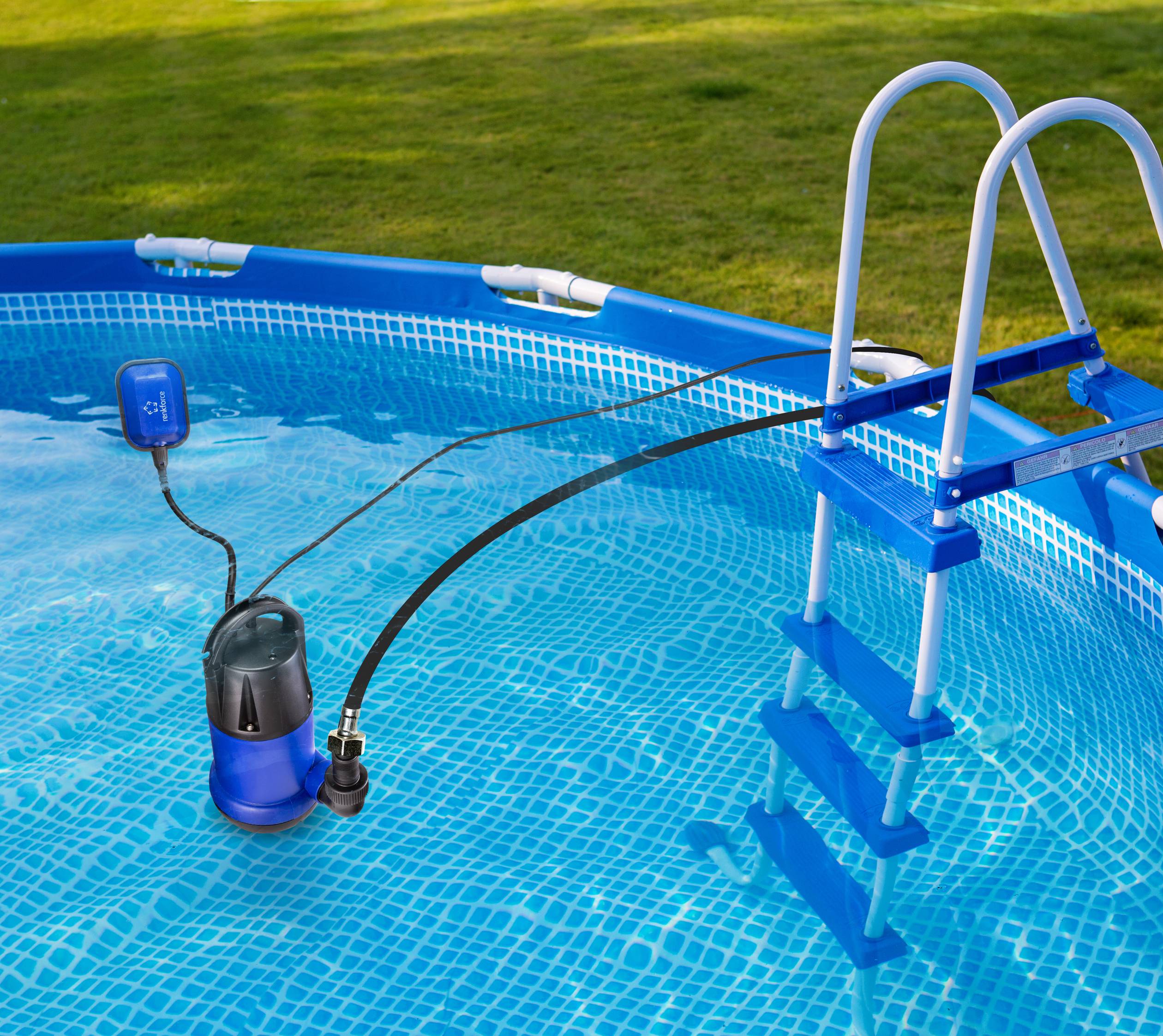 Une pompe de vidange bleue évacue l'eau d'une piscine extérieure ronde. La pompe est suspendue à un tuyau noir qui traverse l'échelle de la piscine.